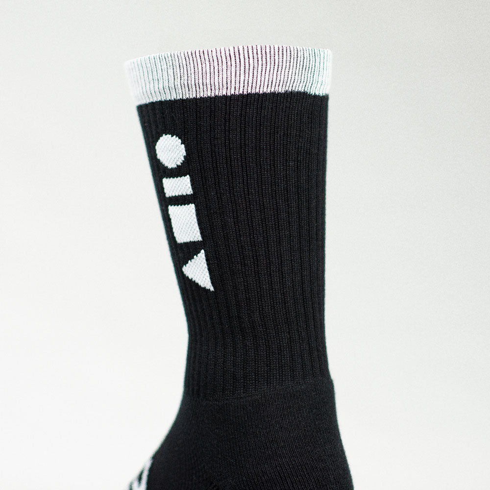 Clay Active black athletic crew socks showing cushioning in studio.