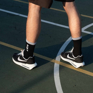 Clay Active men's athletic crew sock black colour shot against basketball court with Nike shoes.