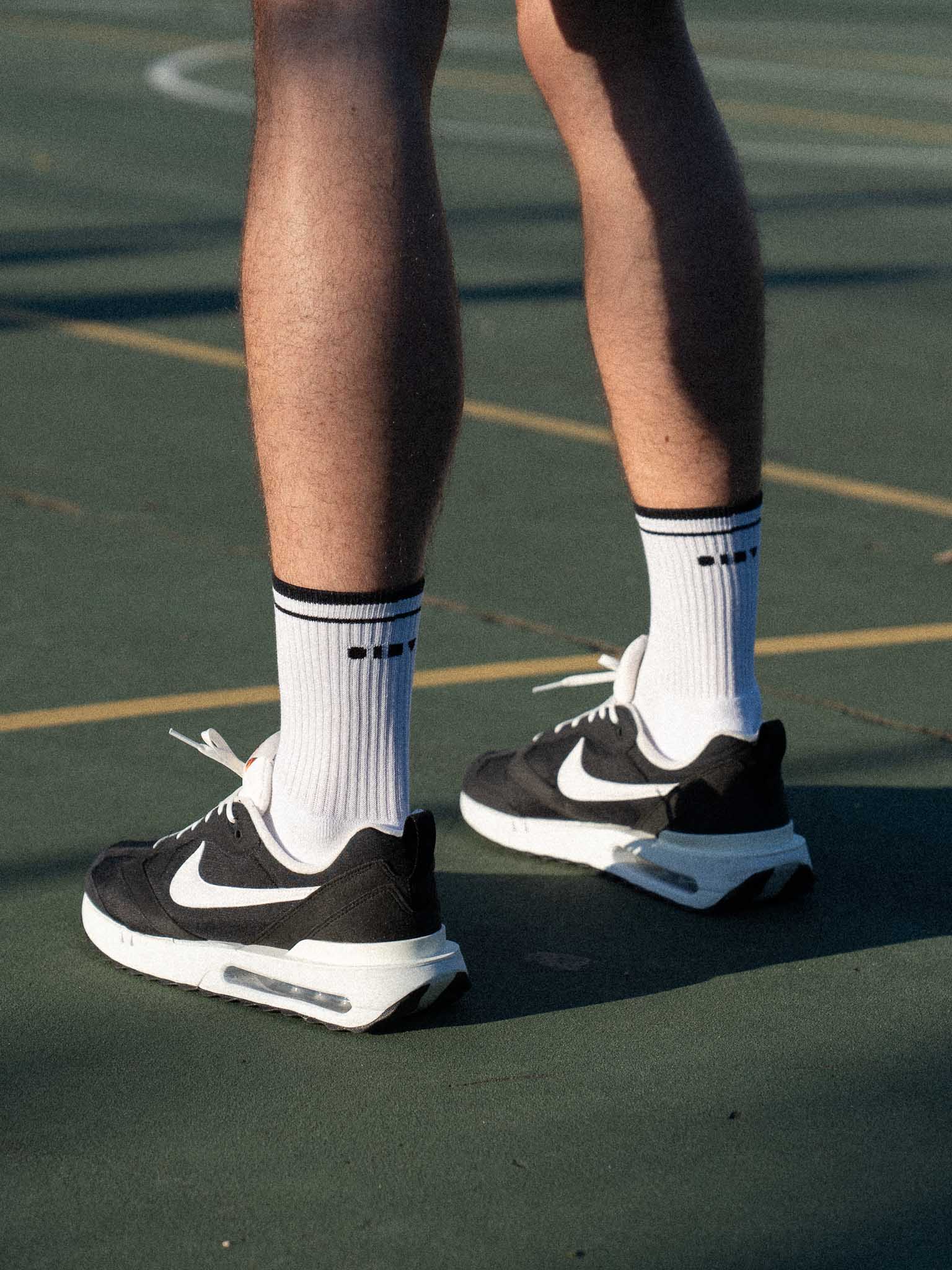 Clay Active men's tennis sock with Nike shoes on court.