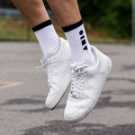 Lifestyle shot of Clay Active men's white athletic sock on basketball court.