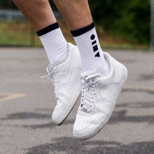 Lifestyle shot of Clay Active men's white athletic sock on basketball court.