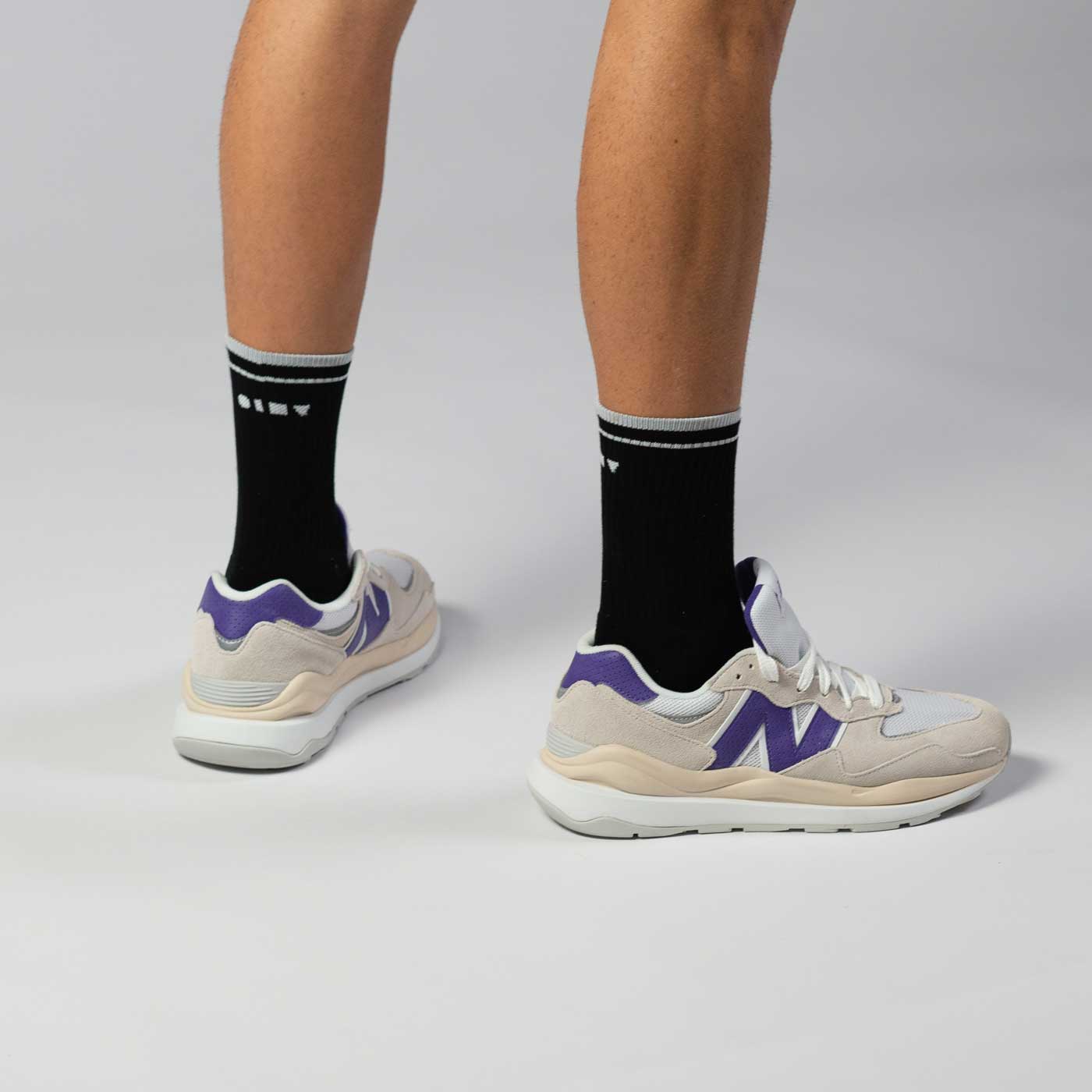 Clay Active's black retro court tennis socks with New Balance shoes in studio.