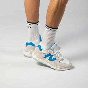 Clay Active's white retro court men's tennis socks in studio with New Balance shoes.